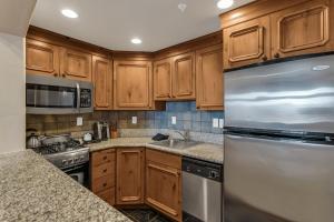 a kitchen with wooden cabinets and a stainless steel refrigerator at Zermatt Mountain Suite and 1BDR in Midway