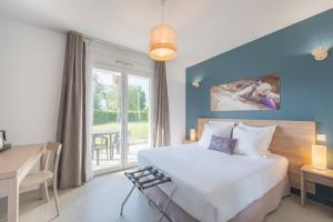 a bedroom with a bed and a desk and a window at Comfort Aparthotel Cannes Mandelieu in Mandelieu-La Napoule +105 photos