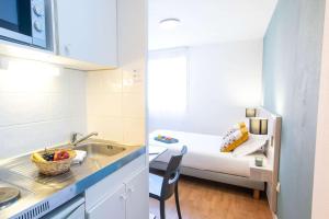 a small kitchen with a sink and a bed in a room at Comfort Aparthotel Aix Le Tholonet in Aix-en-Provence +24 photos