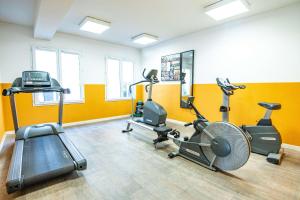 a gym with several exercise equipment in a room at Comfort Aparthotel Aix Le Tholonet in Aix-en-Provence