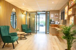 a waiting room with green chairs and a table at Comfort Aparthotel Besancon Hauts du Chazal in Besançon