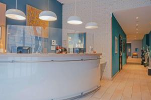 a lobby of a salon with a counter and lights at Comfort Aparthotel Saint-Etienne in Saint-Étienne