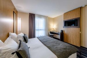 a hotel room with a bed and a desk at Comfort Aparthotel Bordeaux Begles Arena in Bègles +72 photos