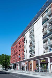 a large apartment building on the side of a street at Comfort Aparthotel Nimes Centre in Nîmes