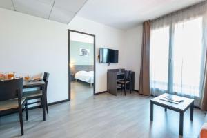 a hotel room with a desk and a mirror at Comfort Aparthotel Nimes Centre in Nîmes