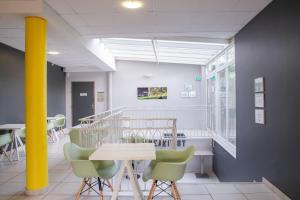 a waiting room with a table and chairs in a building at Comfort Aparthotel Frejus La Tour de Mare in Fréjus