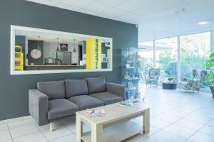 a living room with a couch and a table at Comfort Aparthotel Frejus La Tour de Mare in Fréjus