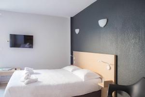 a bedroom with a white bed and a tv at Comfort Aparthotel Frejus La Tour de Mare in Fréjus +60 photos