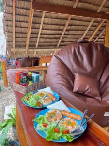 a table with two plates of food on a couch at Khao Phang Camping in Ban Pha Saeng Lang