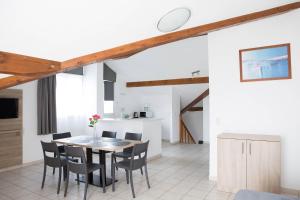 a kitchen and dining room with a table and chairs at Comfort Aparthotel Divonne La Versoix in Divonne-les-Bains