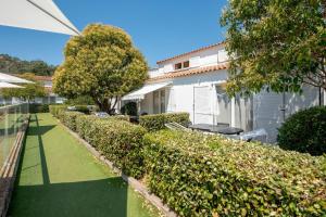 a garden with a bench in front of a house at Comfort Aparthotel Mandelieu la Napoule Village in Mandelieu-La Napoule