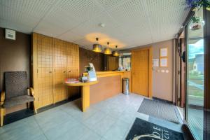 a restaurant with a counter and a chair in a room at Comfort Aparthotel Mutzig Portes d'Alsace in Mutzig