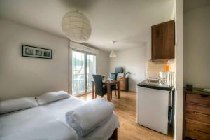 a bedroom with a bed and a kitchen with a table at Comfort Aparthotel Lourdes L'Acacia in Lourdes +41 photos