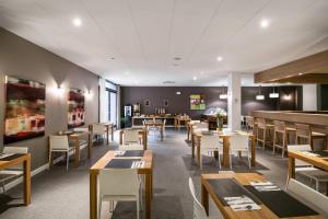 a dining room with wooden tables and chairs at Comfort Aparthotel Lourdes Lorda in Lourdes