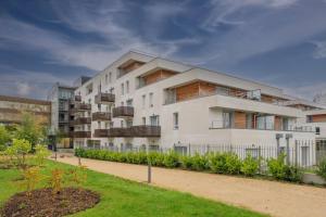 a white apartment building with a balcony at Quality Aparthotel Nancy Zenith in Laxou