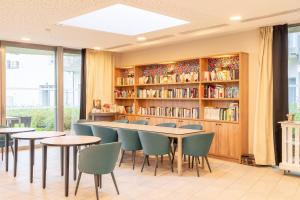 a library with tables and chairs and bookshelves at Quality Aparthotel Nancy Zenith in Laxou
