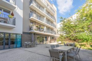 a patio with tables and chairs in front of a building at Quality Aparthotel Parc Marne la Vallée in Bailly-Romainvilliers