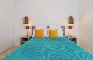 a bedroom with a green bed with two lamps at Quality Aparthotel Parc Marne la Vallée in Bailly-Romainvilliers