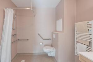 a white bathroom with a toilet and a sink at Quality Aparthotel Parc Marne la Vallée in Bailly-Romainvilliers +12 photos