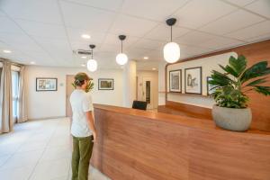 a man is standing in a waiting room at Quality Aparthotel Moissy-Cramayel in Moissy-Cramayel