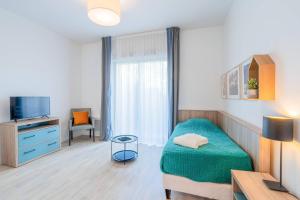 a small room with a bed and a tv at Quality Aparthotel Moissy-Cramayel in Moissy-Cramayel +23 photos