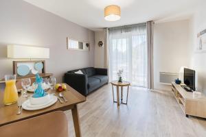 a living room with a couch and a table at Quality Aparthotel Dinan in Dinan
