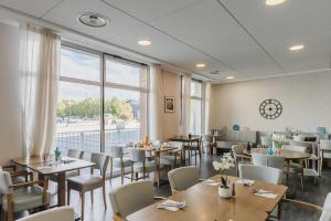 a restaurant with tables and chairs and a large window at Quality Aparthotel Dinan in Dinan