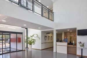 an office lobby with a man standing at a desk at Quality Aparthotel Orleans Sud Zenith in Olivet
