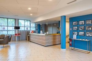 an office lobby with a reception counter and blue walls at Quality Aparthotel Rochefort in Rochefort