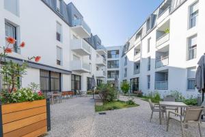 a courtyard with tables and chairs in a building at Quality Aparthotel Rochefort in Rochefort