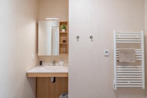 a bathroom with a sink and a mirror at Quality Aparthotel Rochefort in Rochefort +21 photos