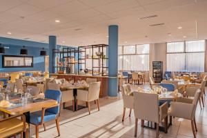 a dining room with tables and chairs and a restaurant at Quality Aparthotel Rochefort in Rochefort