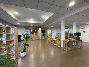 an office lobby with yellow chairs and a table at Quality Aparthotel Valenciennes in Valenciennes