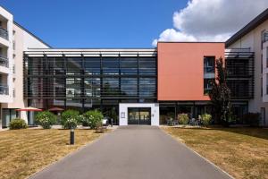 an office building with a walkway in front of it at Quality Aparthotel Portes de Rennes in Bruz