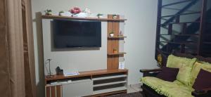 a living room with a flat screen tv on a wall at Casita Oliveira in Serra Negra +10 photos