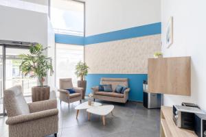 a living room with two chairs and a table at Quality Aparthotel Lyon L'Isle-d Abeau in LʼIsle-dʼAbeau