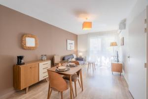 a kitchen and living room with a table and chairs at Quality Aparthotel Lyon L'Isle-d Abeau in LʼIsle-dʼAbeau +12 photos