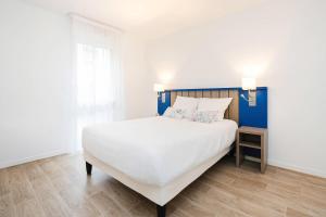 a bedroom with a large white bed and a window at Quality Aparthotel Saint-Malo in Saint Malo +19 photos