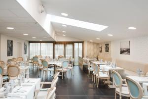 a dining room with white tables and chairs at Quality Aparthotel Saint-Malo in Saint Malo