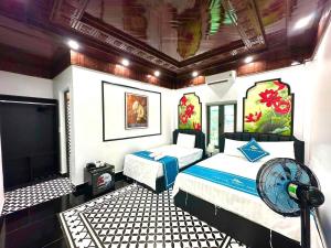 a bedroom with two beds and a flat screen tv at Tam Coc Sunny House in Vũ Lâm