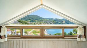 an arched window with a view of the ocean at Yeosu Sky Pension in Yeosu