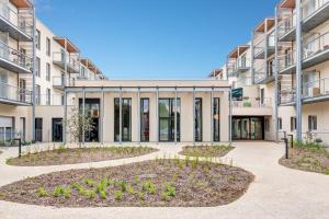 an apartment building with a courtyard with plants at Quality Aparthotel Morangis Orly in Morangis