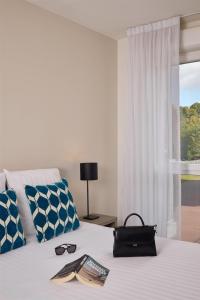 a bedroom with a bed with a book and sunglasses on it at Quality Aparthotel Morangis Orly in Morangis