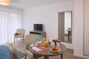 a living room with a table with food on it at Quality Aparthotel Morangis Orly in Morangis