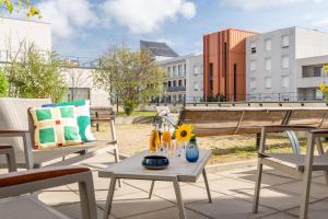 a patio with chairs and a table with a sunflower on it at Quality Aparthotel Bourgoin-Jallieu in Bourgoin