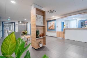 an office lobby with a reception desk and plants at Quality Aparthotel Bourgoin-Jallieu in Bourgoin
