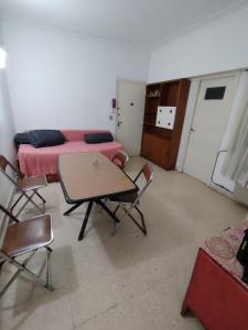 a room with a bed and a table and chairs at Tucumán y Colón in Mar del Plata