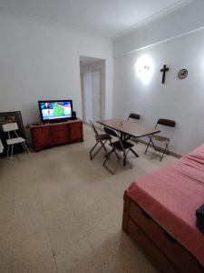 a room with a table and a tv and a bed at Tucumán y Colón in Mar del Plata