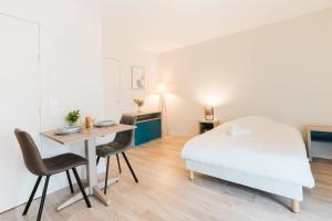 a bedroom with a bed and a desk and a table at Quality Aparthotel St-Berthevin Laval in Saint-Berthevin-sur-Vicoin