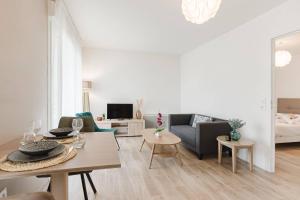 a living room with a couch and a table at Quality Aparthotel St-Berthevin Laval in Saint-Berthevin-sur-Vicoin